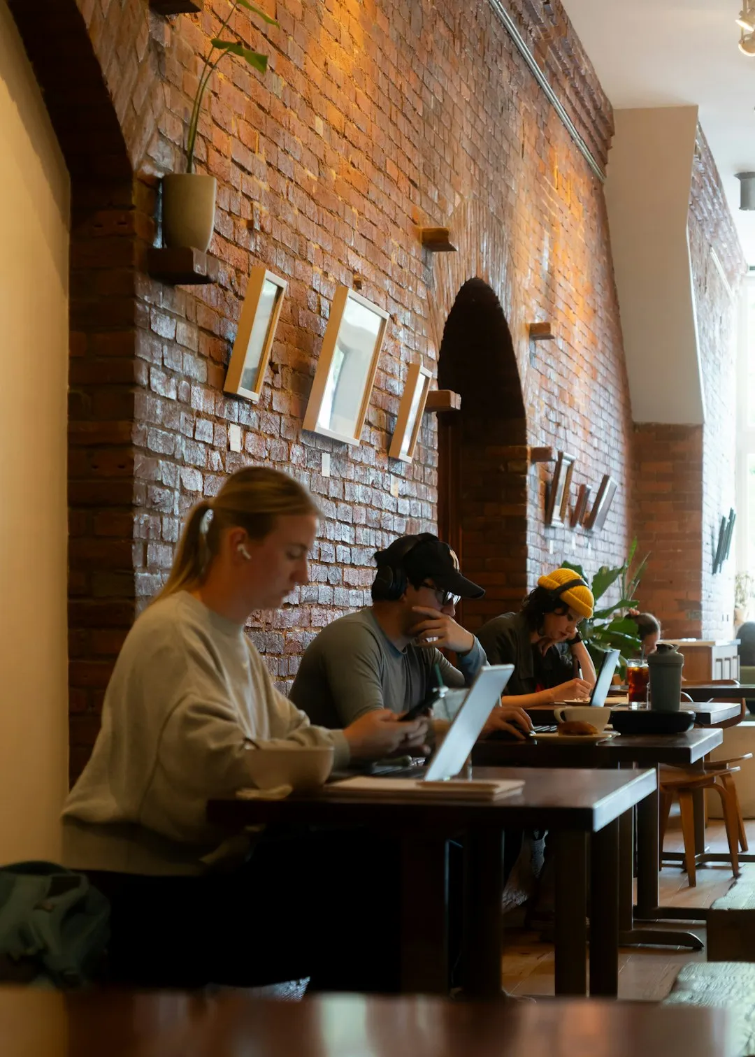 People working on laptops in a cozy cafe.